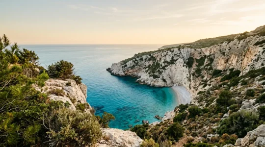 Vue panoramique d'une crique sauvage méditerranéenne encaissée entre des falaises calcaires, eaux turquoise cristallines et végétation préservée