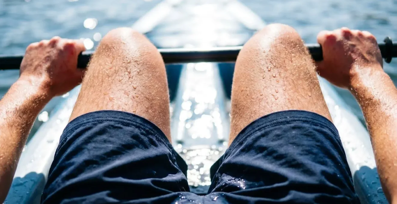 Gros plan sur les cuisses d'un kayakiste exposées au soleil avec réverbération de l'eau