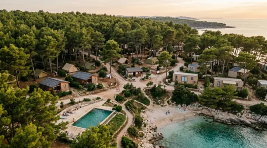 Vue d'ensemble d'un domaine naturiste avec différents types d'hébergements dans un environnement naturel préservé