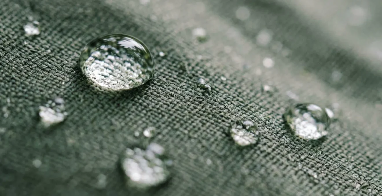 Gros plan sur des gouttelettes d'eau perlant sur une toile de tente imperméabilisée