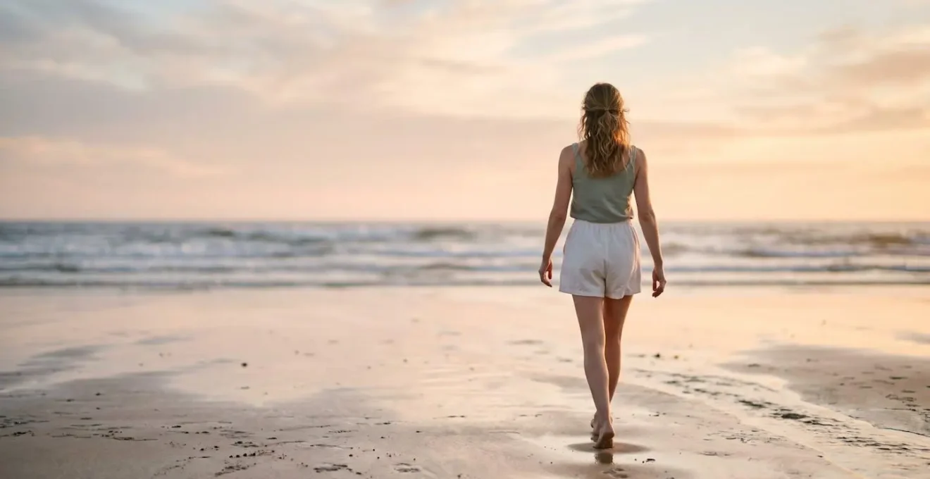 Personne marchant pieds nus sur le sable les bras libres vers l'horizon
